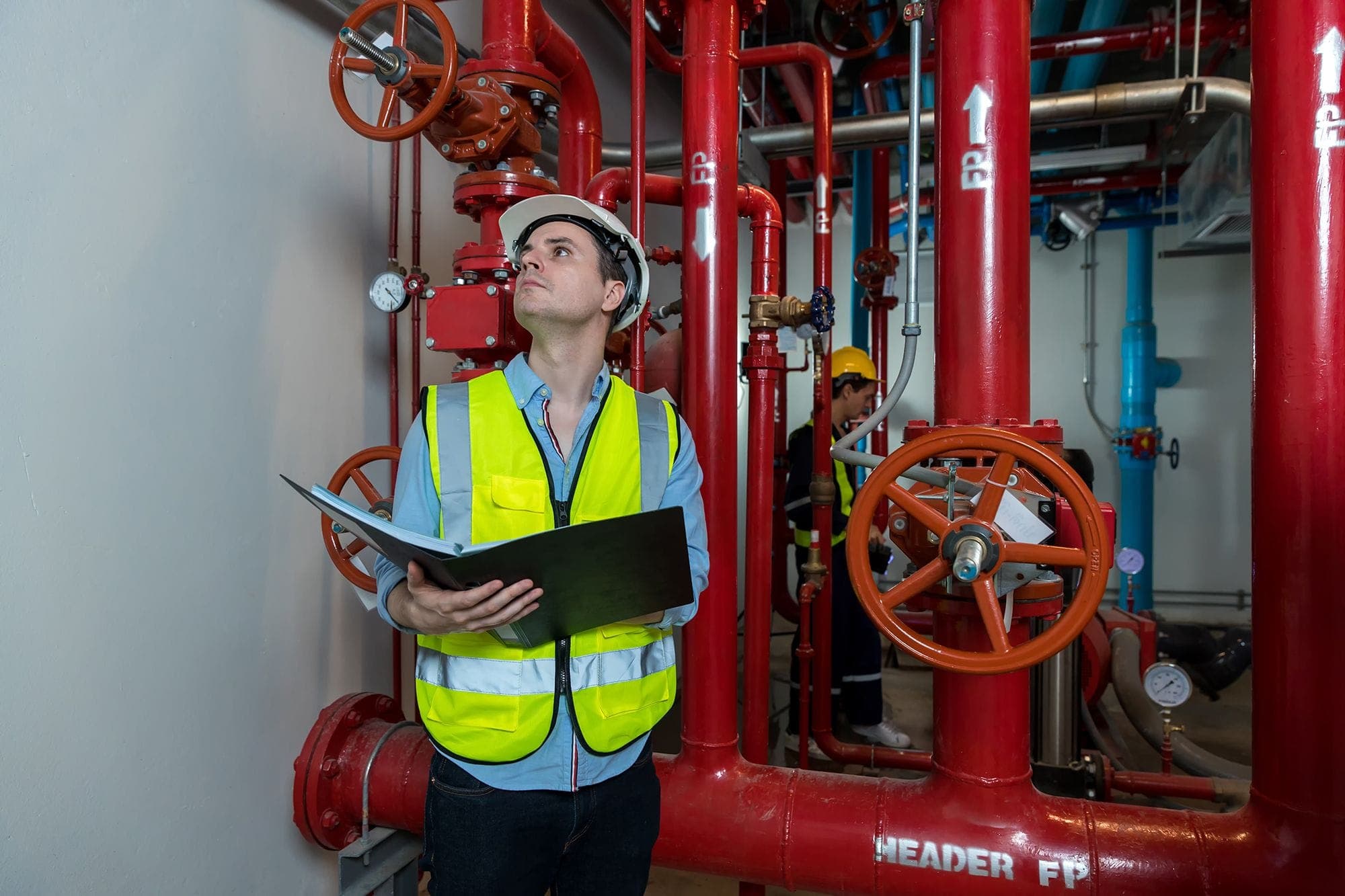 Photograph of an inspector checking off the latest month of the fire inspection record on a fire extinguisher.